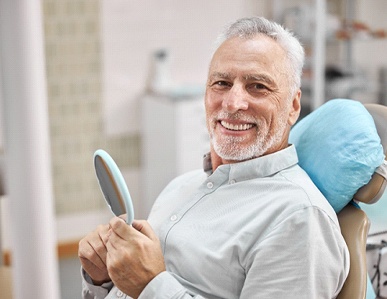 Happy patient at appointment to use dental insurance benefits