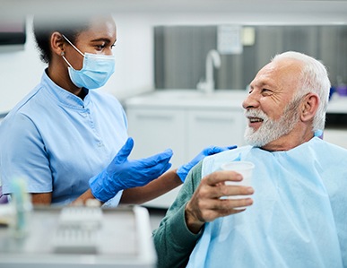 Patient with dentures in Superior talking to dental assistant