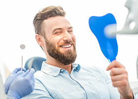 Young man admiring his new dental implants in Superior