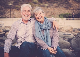 Older couple smiling together while sitting outside