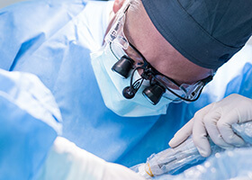implant dentist performing dental implant surgery