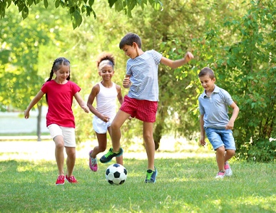 children playing soccer in the park together while wearing mouthguards