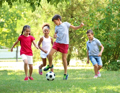 children playing soccer in the park together while wearing mouthguards