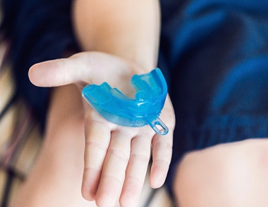 child holding a teeth grinding mouthguard