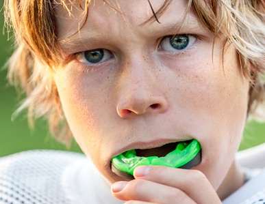 child putting in a sportsguard before a game