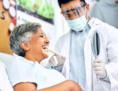 Dentist showing patient smiling in reflection