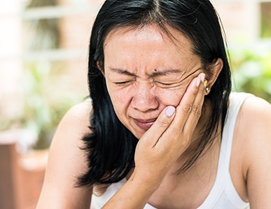 Woman in pain with hand on face