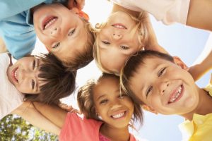 Children smiling and playing outside.