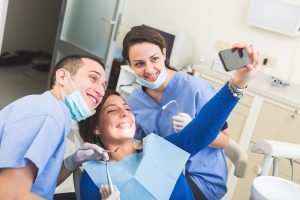 happy patient taking selfie at dentist