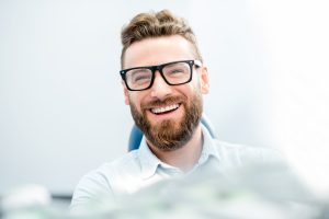 man sitting in dentist chair smiling