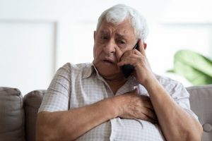 worried person talking on the phone with their dentist about a dental emergency