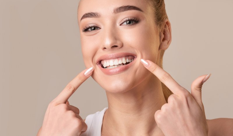 woman pointing at tooth-colored fillings in Superior