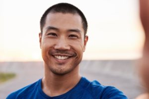 a man smiling during summer with dental implants