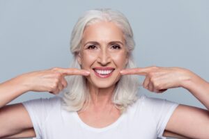 Smiling older woman pointing to her teeth