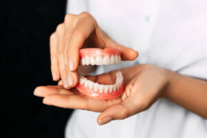 Close up of woman’s hands holding a denture