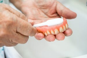 Person brushing their dentures 